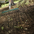 working in the garden with wheel barrow and a green rake