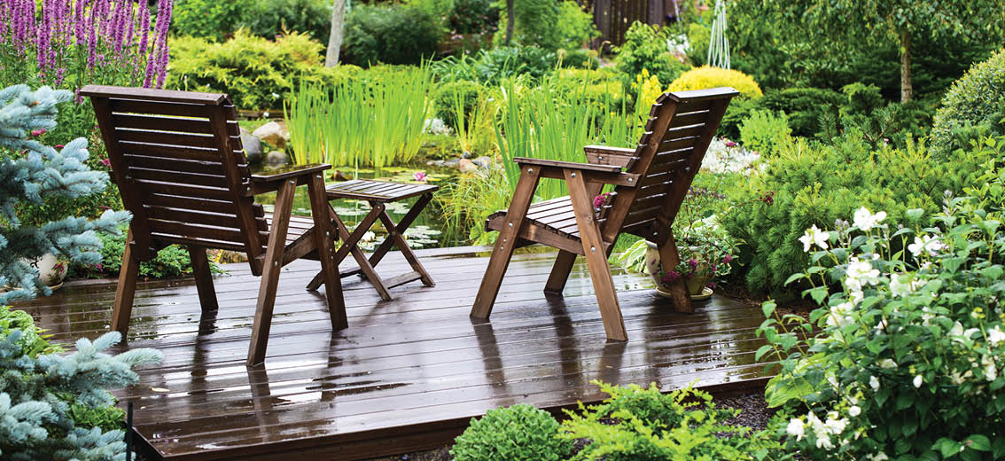 Garden chairs near the pond in a beautiful garden