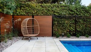 Clôture de piscine en bois et acier entourant piscine creusée dans idées de clôture de piscine