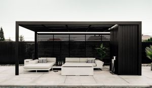 pergola noire adaptable cubrics (pergola bioclimatique) pour grands espaces avec mobilier blanc et sol dallé dans idées de pergolas