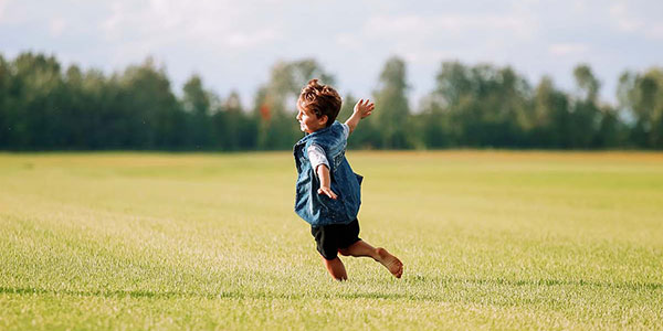 Jeune garçon qui court sur une belle pelouse dans un champs de production de gazon au Québec