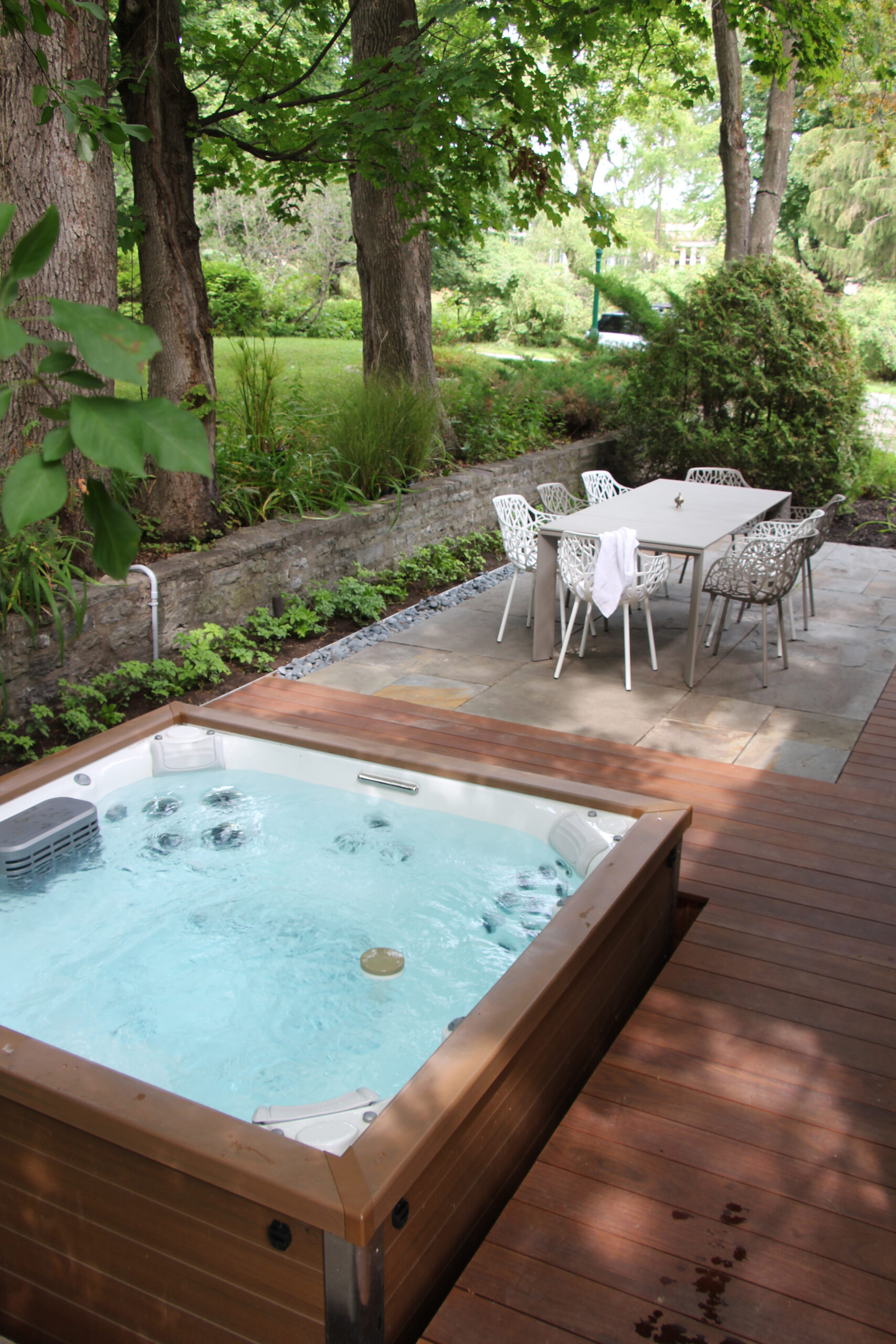Vue d’ensemble d’une terrasse avec spa encastré et mobilier de jardin élégant