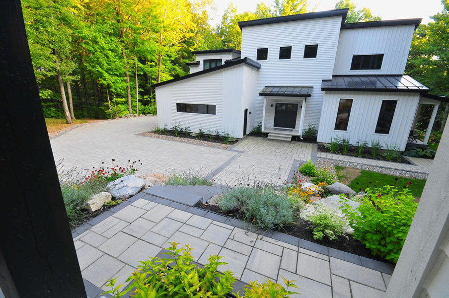 Aménagement paysager fonctionnel devant une résidence contemporaine en forêt